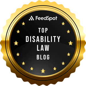 A gold and black circular badge with the text "FeedSpot Top Disability Law Blog" in the center, surrounded by small gold stars.